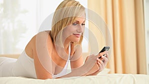 Fairhaired woman sending text messages