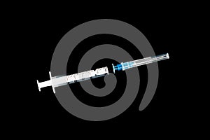 Fairly standard design single use syringe isolated over black background