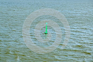 Fairway with green buoy in a sea. Safe movement at sea, navigation.