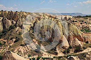 Fairy chimneys and footpaths against a bright blue sky- Cappadocia