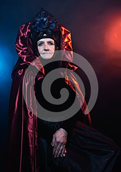 Fairy creature, historical character, fantasy queen, witch, in fairy costume Woman, model after 60, in the studio, dark background