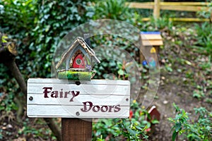 Fairy Doors wooden sign post with fairy houses in charming outdoor fairy garden in Ireland.