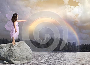 Fairy with pink wings casts a rainbow into the sky