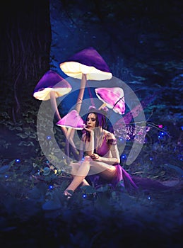 Fairy sitting under huge mushrooms. photo