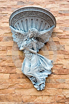 Fairy statue and fountain basin decor on the wall