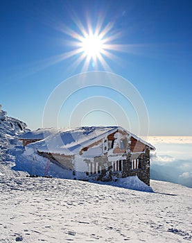 Fairy tale building in wintertime with sun.