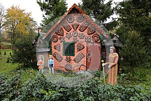 Fairy tale house covered with sweets and Jack and Jill with witch