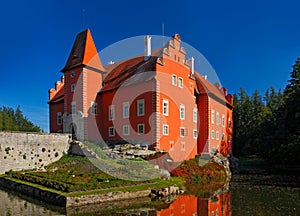 Fairy tale red castle on the lake, with dark blue sky, state castle Cervena Lhota, Czech republic