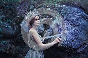 Fairytale girl in beautiful stones. Stones in the moss.