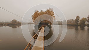 Fairytale house in the middle of the lake on an autumn foggy morning aerial