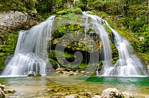 Fairytale Virje waterfall in Slovenia - Pluzna. Dreamy and beautiful natural double waterfall shot on long exposure.