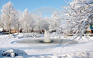 Fairytale winter landscape in Nunspeet, the Netherlands, with frozen pond with fountain