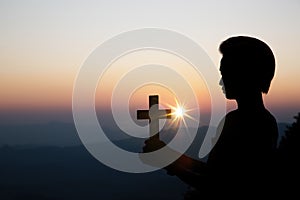 Spiritual prayer hands over sun shine with blurred beautiful sunset background