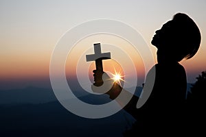 Spiritual prayer hands over sun shine with blurred beautiful sunset background