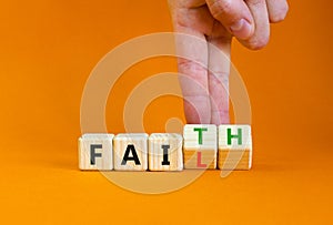 Faith instead fail symbol. Businessman turns wooden cubes and changes the concept word Fail to Faith. Beautiful orange table