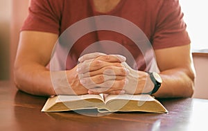 Faith, praying and hands with man, bible and spiritual with religion or worship with guidance or scripture. Closeup, guy