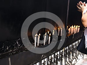 Faithful burning candles in the church in prayer for better days for all