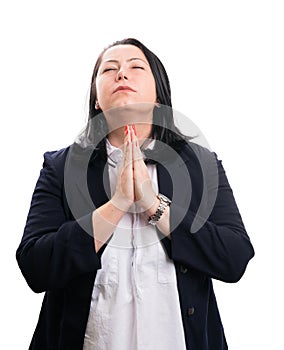 Faithful businesswoman making praying gesture with closed eyes