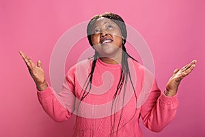 Faithful catholic woman in pink sweather standing with palms faced to sky