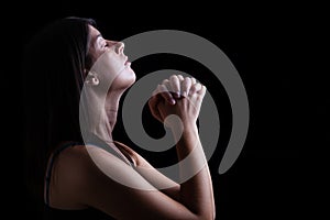 Faithful woman praying, hands folded in worship