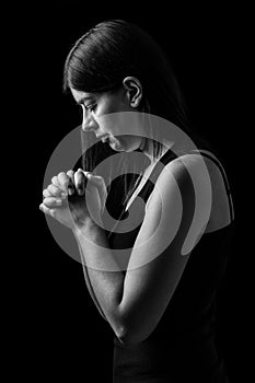 Faithful woman praying, hands folded in worship to god