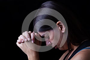 Faithful woman praying, hands folded in worship to god