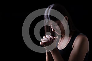 Faithful woman praying, hands folded in worship to god