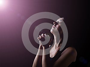 Faithful woman praying under a divine or celestial light photo