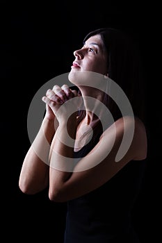 Faithful woman praying in worship to god looking up in hope