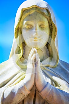 Faithfull Virgin Mary with praying hands and blessing, looking at the sky