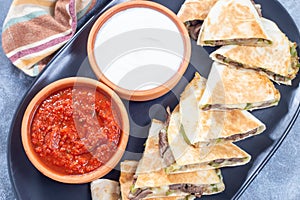 Fajita quesadilla with pieces of beef steak, green bell pepper, onion and cheese, top view