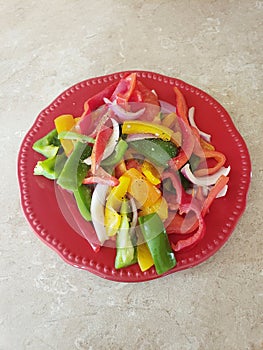 Fajitas mix of vegetables on a round red plate