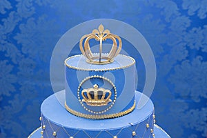 Fake blue birthday cake with a crown on top.