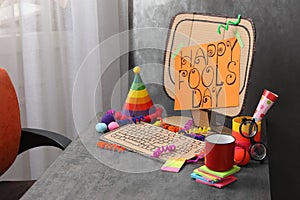 Fake computer with words Happy Fool`s Day on table in office