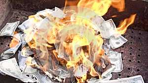 Fake dollars are on fire. Burning counterfeit money in the grill.