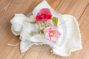 Fake flower in pile white fabric on wooden board
