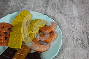 Fake food in a blue plate on a white background