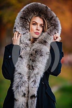 Fake fur fabric. Elegant girl walk in autumn park. Fur garments. Really warm and cozy. Expensive clothes. Luxury segment