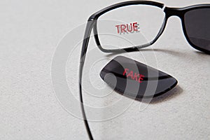 Fake news, disinformation or false information and propaganda concept. . Broken glasses with the inscription photo
