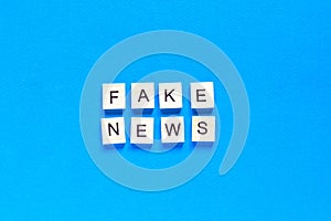 Fake news word alphabet letters on blue background. top view. flat layout photo
