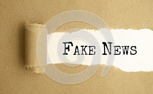 Fake news words on torn paper background