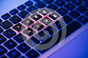 Fake news written on a backlit keyboard in a blue ambiant light