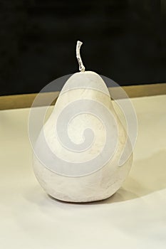 Fake pear colored with white on white paper