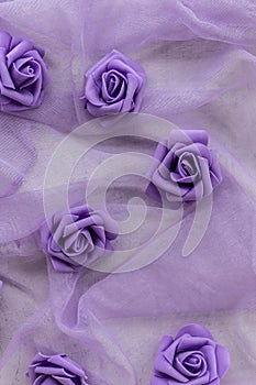 fake purple roses on chiffon fabric in purple or lilac color for backgrounds.