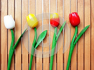 Fake tulips on wood background