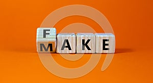 Fake it until you make it symbol. Turned a cube and changed the word `fake` to `make`. Beautiful orange background. Business, photo