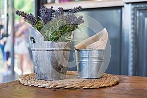 Faked flowers in wooden bucket and napkin paper in bucket