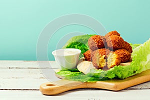 Falafel balls served with pita and tahini sauce on a wooden board