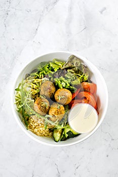 Falafel and fresh vegetables mixed salad on white background, top view. Vegetarian, food concept