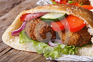 Falafel with fresh vegetables in pita bread close-up